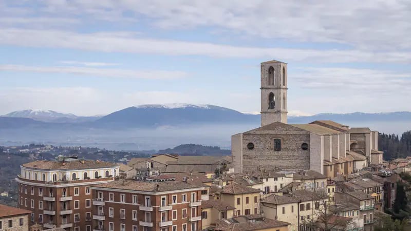 Perugia con il campanile di San Pietro e le montagne dell'Umbria